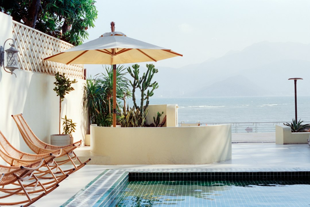 Corporate executive working on laptop on luxury hotel pool terrace during a seamless bleisure trip