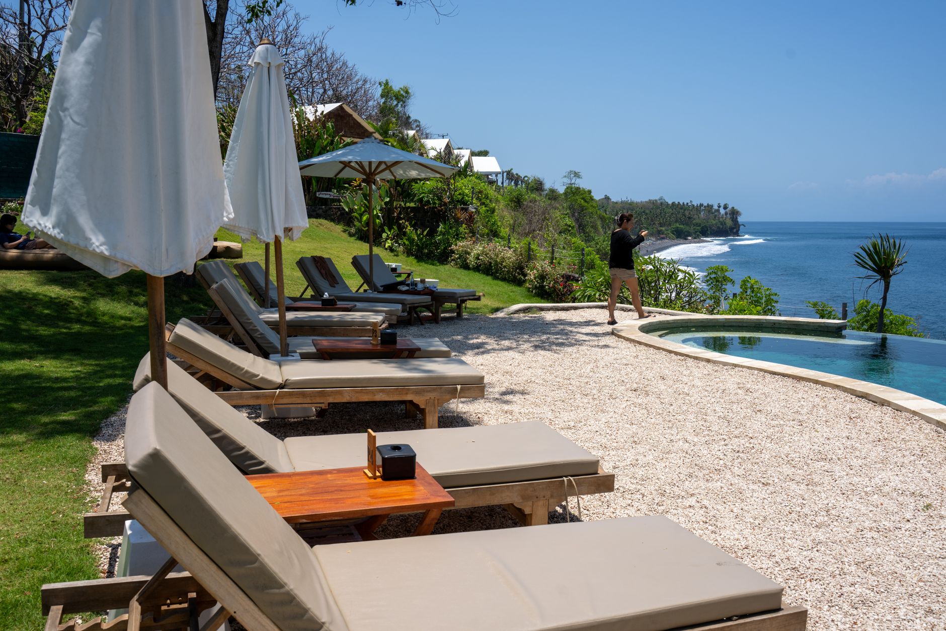 Travel consultant recording smartphone video review overlooking luxury resort pool